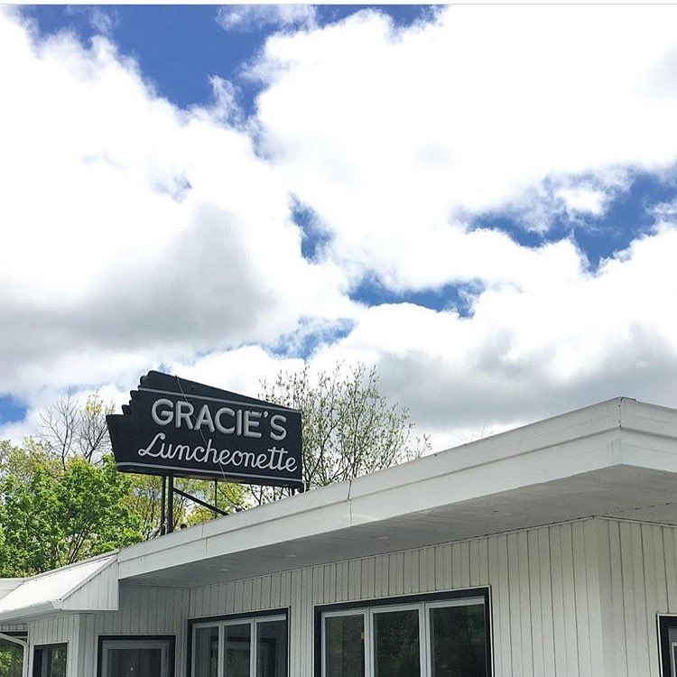 Gracie’s roadside sign above the luncheonette under a blue sky